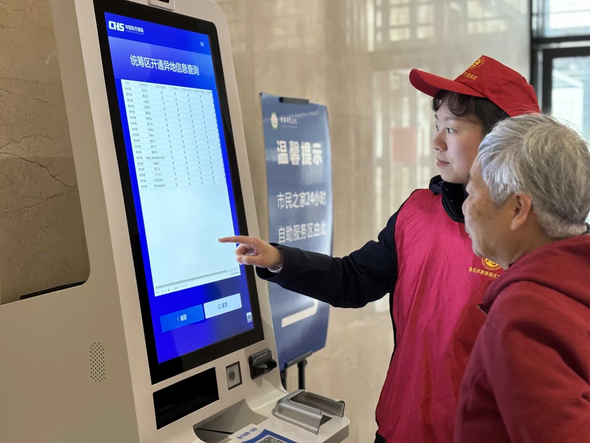政务服务志愿者指导老年居民使用自助查询终端